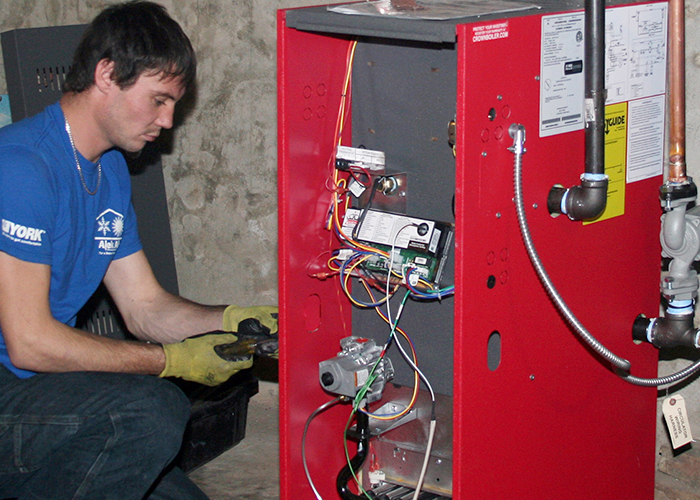 Un hombre trabaja en una unidad de calefacción.