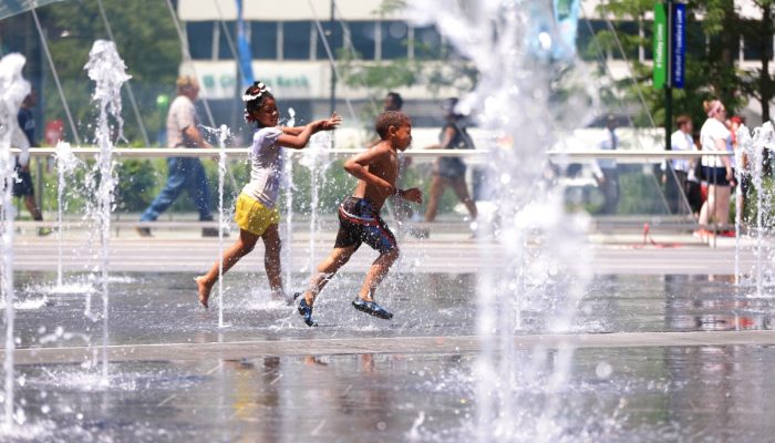 Two children run through the water at the Dilworth Park sprayground