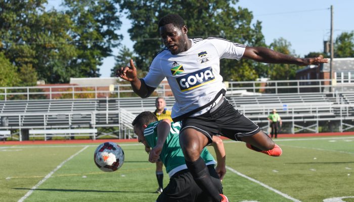 Un jugador del equipo de Jamaica en el aire, por encima del balón de fútbol