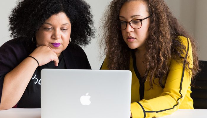 Dos mujeres que miran una computadora portátil