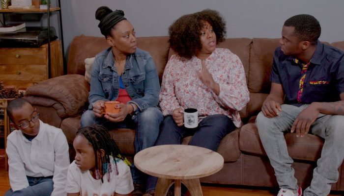 Una familia se sienta junta en un sofá y habla