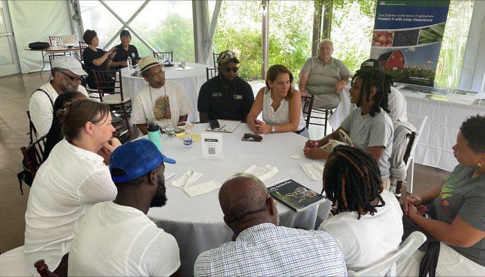 People gather around a table at a conference.