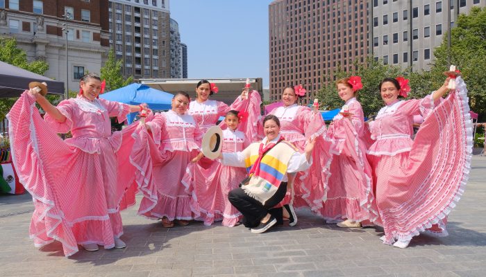 A group of women and young person pose in traditional cultural clothing