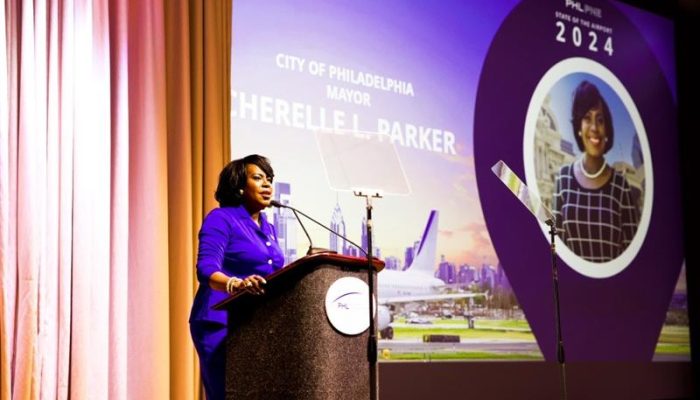 Mayor Cherelle L. Parker speaking behind a podium at the PHL International Airport’s “State of the Airport” meeting at the Pennsylvania Convention Center