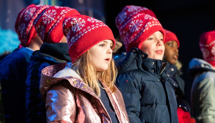 A group of young children perform on a stage.