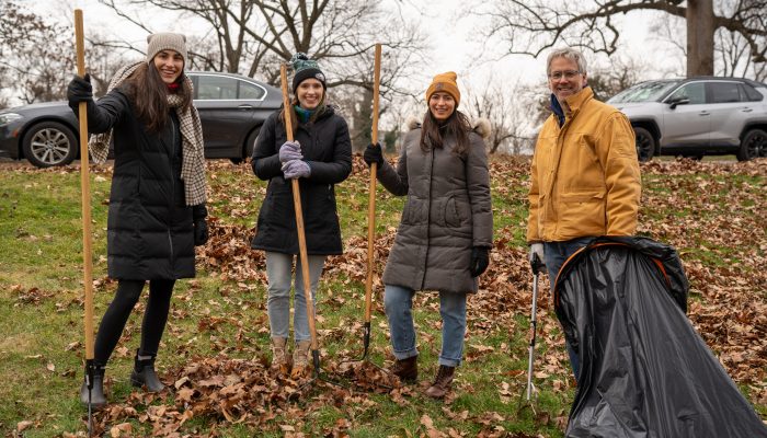 Volunteers pose with gardening tools.